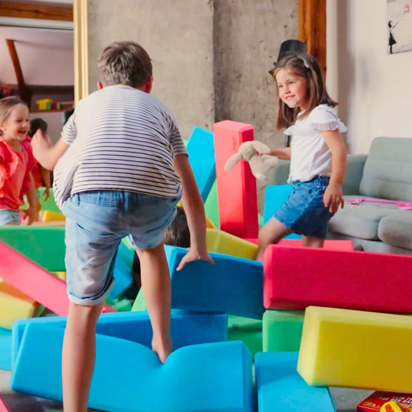 Children playing on colorful foam blocks in a playroom. RIWI blocks