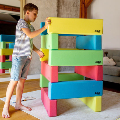 Child playing with colorful foam blocks indoors RIWI blocks