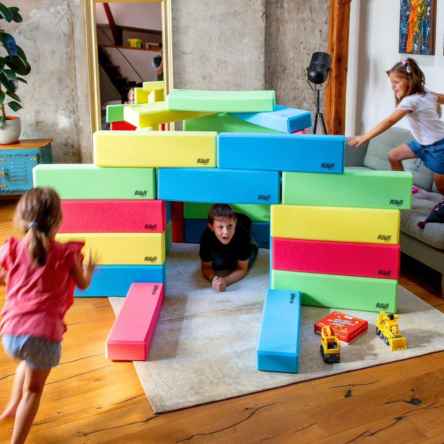 Children playing with colorful building blocks in a living room. RIWI blocks